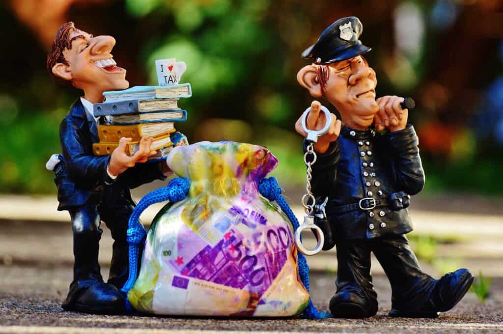 Two claymation characters, one is a policeman with handcuffs and one is a man in a suit carrying a stack of books. There is a bag of printed money between them.