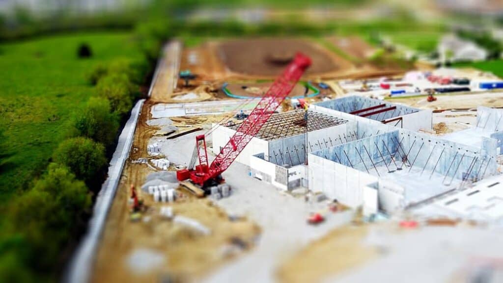Photo of a model built to scale of an industrial construction site with a crane lifting rooftop units