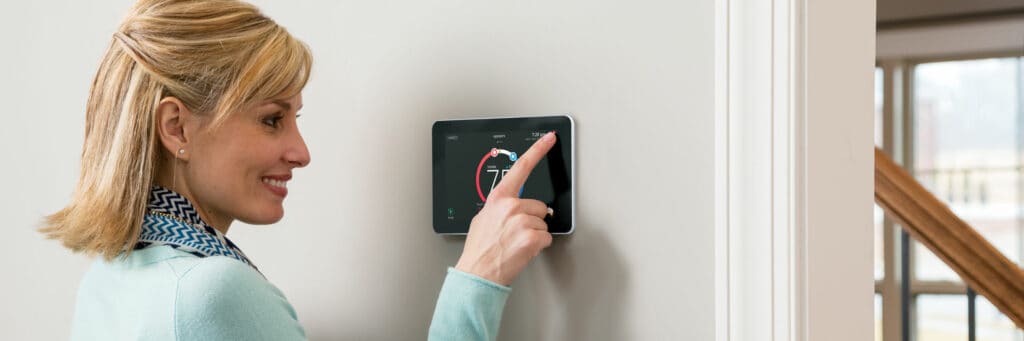 Photo of woman adjusting iComfort Smart Thermostat