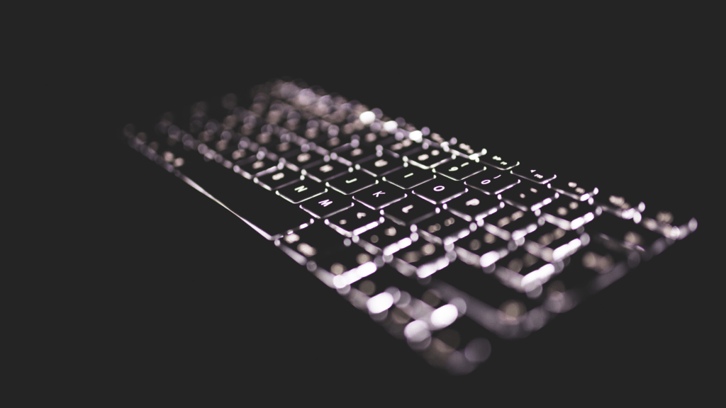 Photo of a keyboard with backlit keys on a dark background