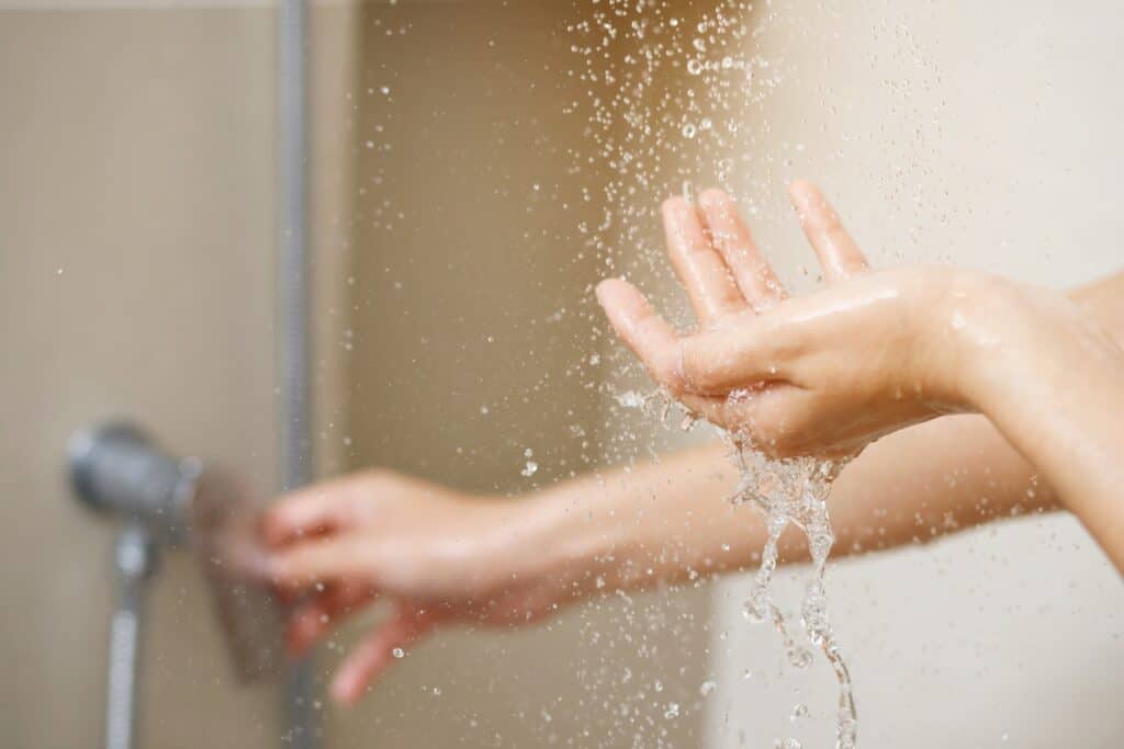 a womans hand testing the temperature of her water because hot water heater is not working