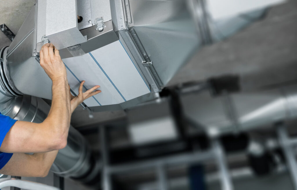 HVAC professional installing a new commercial HVAC filter
