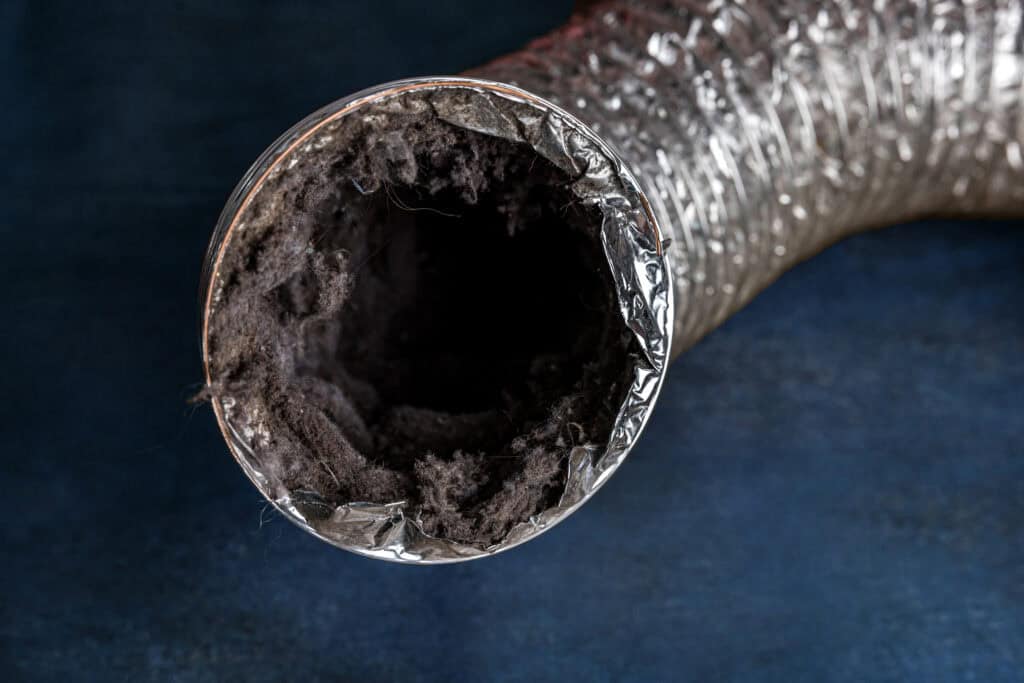 A dirty vent duct ductwork filled with lint, dust and dirt creating poor indoor air quality